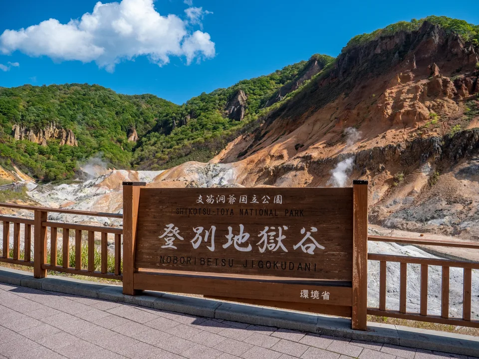 The Noboribetsu Jigokudani sign in front of steaming volcanic slopes