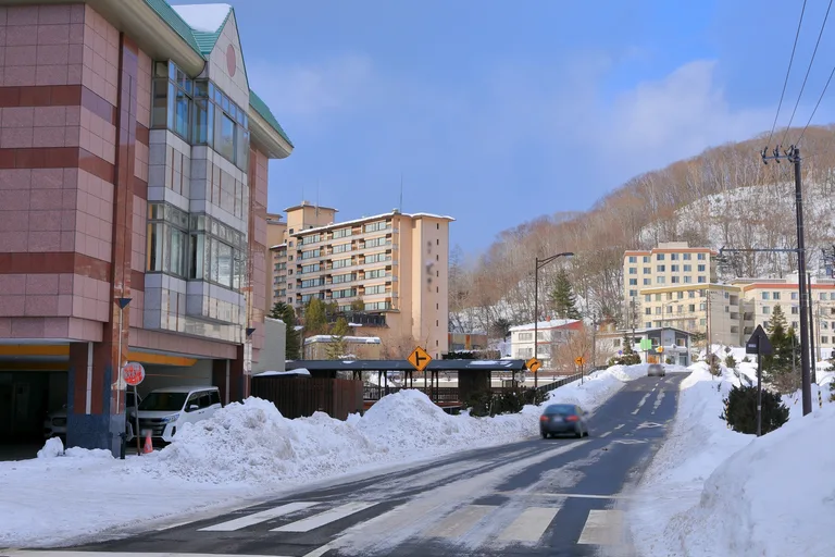 Hotels and snowbanks beside a road in Noboribetsu Onsen in winter