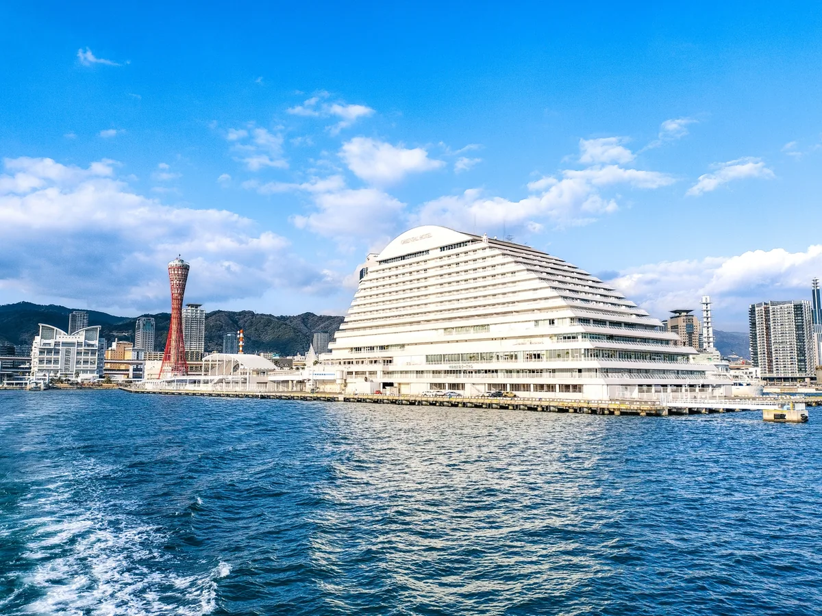 Kobe Port Tower and waterfront buildings seen across blue harbor water