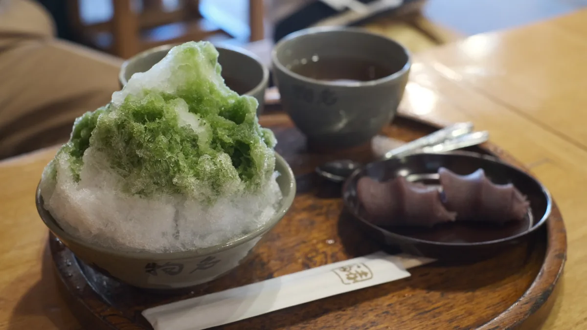 Green tea shaved ice, a cup of tea and Akafuku red-bean sweets on a wooden tray