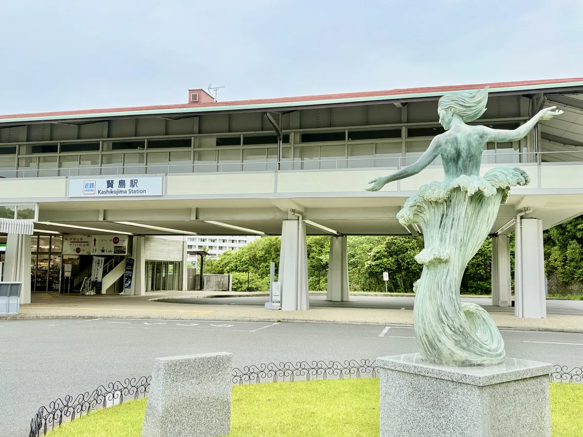 Kashikojima Station entrance with a green statue in the foreground