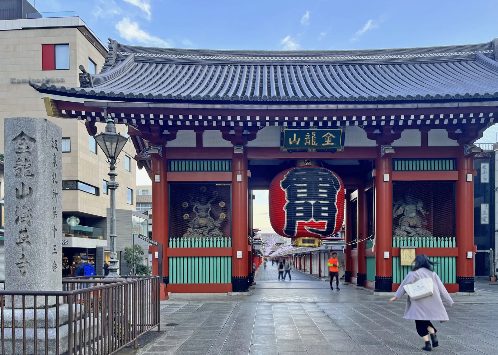 A traveler approaching Kaminarimon gate on a quiet morning in Asakusa