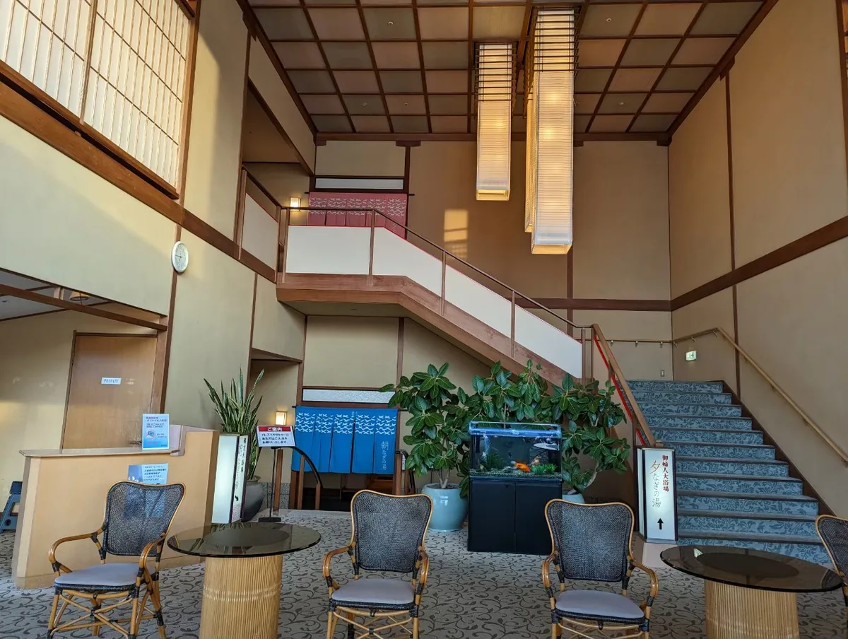 Chairs and a small table beside a staircase and indoor greenery at Hojoen