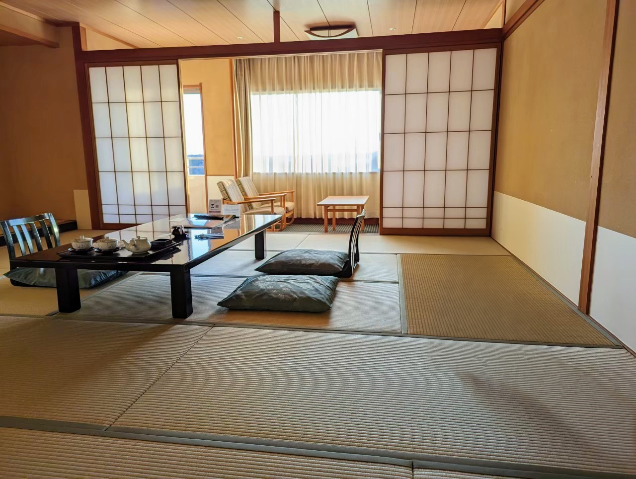 Our Japanese-style room with tatami flooring, a low table, floor cushions, shoji screens and seating by the window