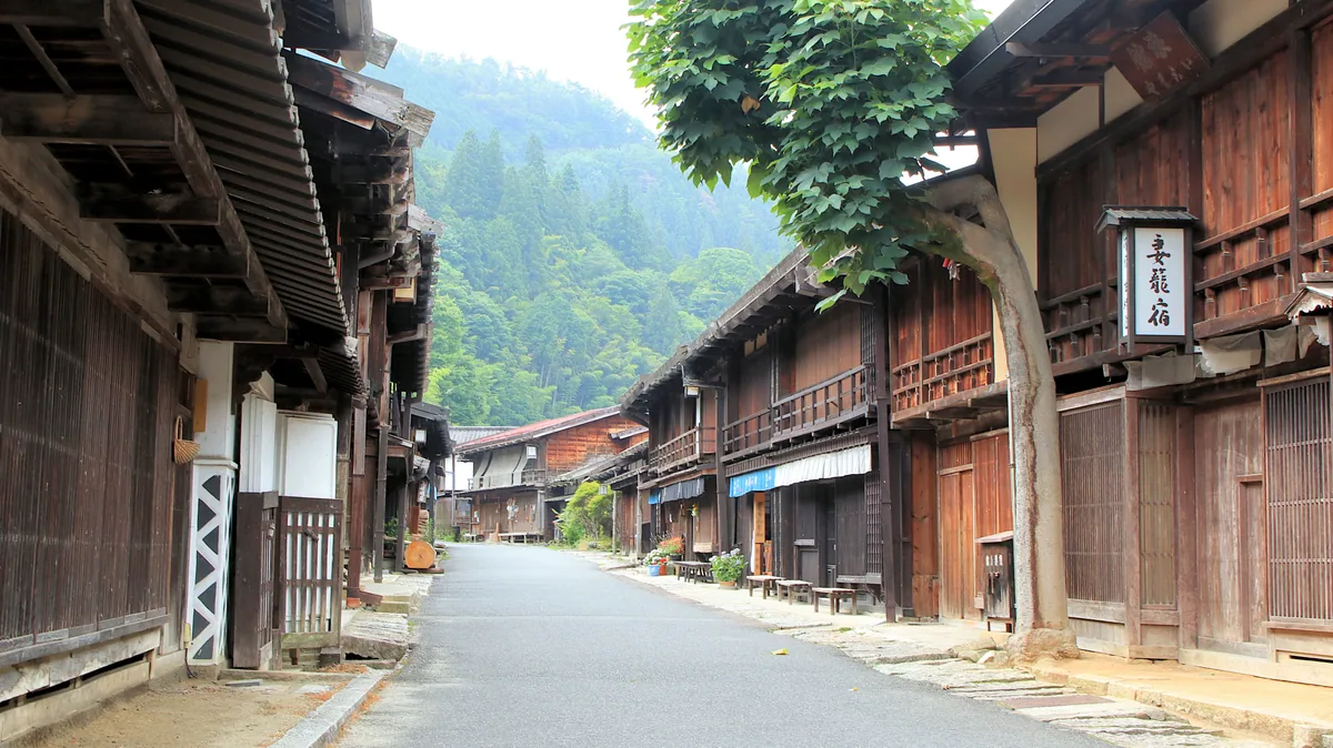 Wooden shopfronts along a quiet summer street in Tsumago