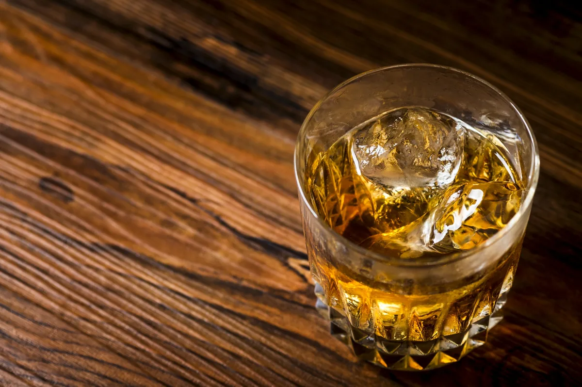 A glass of whisky with ice, shown as an illustrative photograph