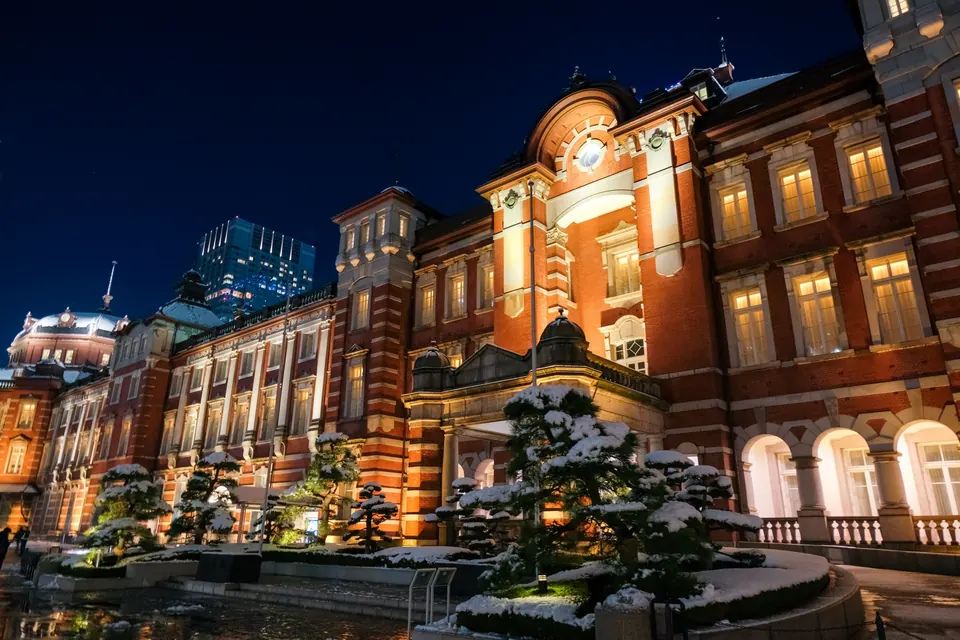 Tokyo Station illuminated at night, with snow on the plantings and ground outside